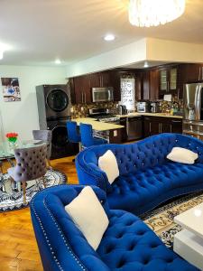 a living room with blue couches and a kitchen at Osas Luxury Stay in Queens