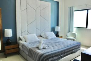 a bedroom with a bed with a teddy bear on it at Hermoso en marina, asombrosas vistas by G P S rentas in Mazatlán +24 photos
