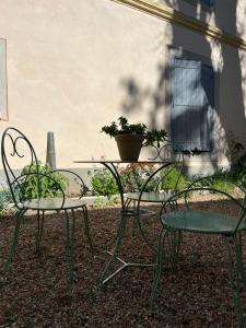 a table and two chairs and a table with a potted plant at La maison des Dames Marie in Coursan