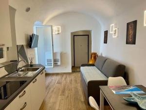 a small living room with a couch and a kitchen at La conchiglia in Ceriale +31 photos