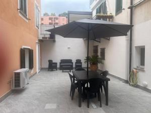 a black table and chairs with an umbrella on a courtyard at La conchiglia in Ceriale