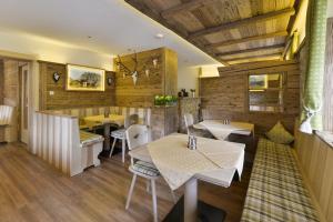 ein Restaurant mit Holzwänden, Tischen und Stühlen in der Unterkunft Pension Widderstein in Lech am Arlberg