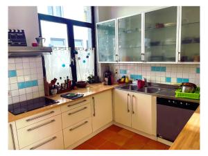 Una cocina con gabinetes blancos y un fregadero. en Chambre double dans maison lumineuse Saint Job Uccle, en Bruselas