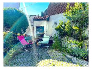 Dos sillas sentadas en un jardín con un arcoíris en Chambre double dans maison lumineuse Saint Job Uccle, en Bruselas