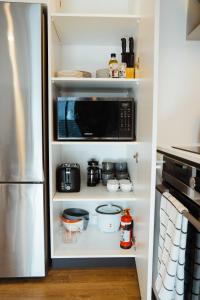 a kitchen with a refrigerator and a microwave at New townhouse, 300m 4 minute walk Te Kaha One New Zealand Stadium, car park, 2 bed 2 bath in Christchurch +11 photos