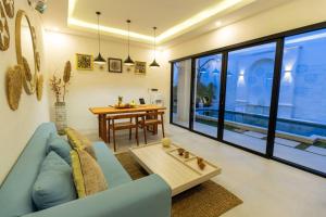 レギャンにあるChic modern villa, 5 minute walk to Legian beachの青いソファとテーブルのあるリビングルーム