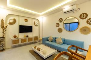 レギャンにあるChic modern villa, 5 minute walk to Legian beachの青いソファとテレビのあるリビングルーム