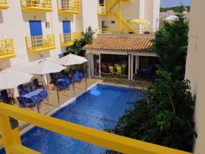 einen Pool im Innenhof eines Gebäudes mit Stühlen und Sonnenschirmen in der Unterkunft Bellavista Hotel & Spa in Cala Ratjada