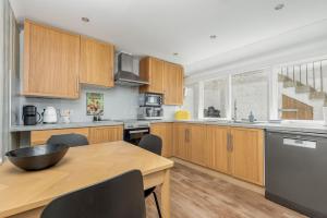 Una cocina con gabinetes de madera y una mesa de madera. en Greyfriar's Snug, en St Andrews