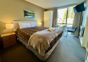 een hotelkamer met een bed met handdoeken erop bij Brinkley Resort in Methven