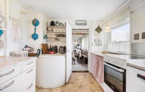 里伯Stunning Home In Ribe的厨房配有白色橱柜和大窗户