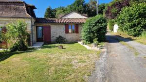 a small house with a yard next to a road at Studio rural au calme in Bourgnac