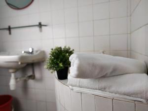 ein Badezimmer mit Handtüchern, einem Waschbecken und einer Topfpflanze in der Unterkunft Homey 9pax 3BR MRT Cheras Tmn Suntex I HomeBrickz in Cheras