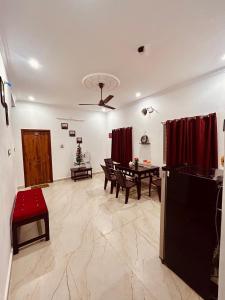a living room with a table and red curtains at DE Villa Breeze @ Beach side in Puducherry