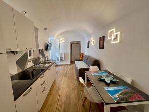 a kitchen and living room with a couch and a table at La conchiglia in Ceriale