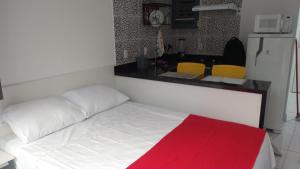 Habitación con cama blanca con manta roja en Apartamento na Praia de Botafogo, en Río de Janeiro