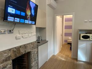 a living room with a fireplace with a tv above it at Etrusco Viola - Suite Giglio Rosso in Bagno a Ripoli