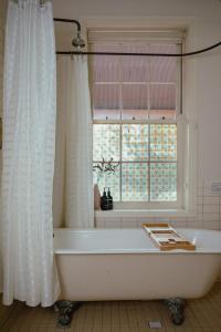 La salle de bains est pourvue d'une baignoire et d'une fenêtre. dans l'établissement Bluebush Estate, à Lovedale