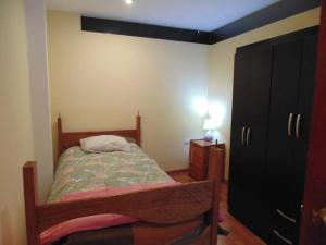 niewielka sypialnia z łóżkiem i komodą w obiekcie Apartamento privado y acogedor w Cuzco