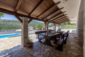 a patio with a table and chairs and a pool at Villa Relax, private pool,barbecue! in Omiš