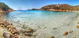 a beach with rocks in the water and a mountain at Al 28ᴀ , Appartamento Teulada in Teulada