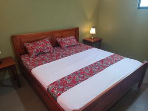 un letto con cuscini rossi sopra in una camera da letto di Mango Guesthouse a Pangandaran