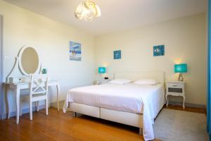 Un dormitorio con una cama, un escritorio y un espejo. en Beautiful family house with a large terrace, en Saint-Martin-de-Ré