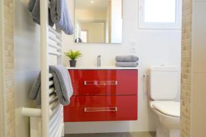 baño con armario rojo junto a un aseo en Beautiful family house with a large terrace, en Saint-Martin-de-Ré