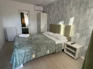 Un dormitorio con una cama grande y una mesita de noche. en Villa Raul, en Costinesti