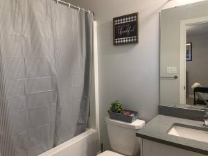 a bathroom with a shower and a toilet and a sink at Exquisite 3 BR Villa with Double Garage-King Bed in Regina +21 photos
