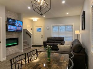 a living room with a couch and a table at Exquisite 3 BR Villa with Double Garage-King Bed in Regina