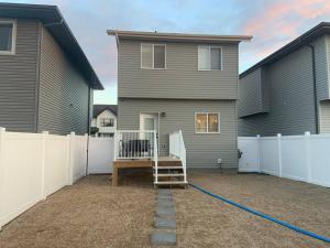 a backyard with a house and a fence at Exquisite 3 BR Villa with Double Garage-King Bed in Regina
