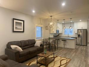 a living room with a couch and a kitchen at Exquisite 3 BR Villa with Double Garage-King Bed in Regina