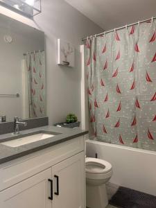 a bathroom with a toilet and a shower curtain at Exquisite 3 BR Villa with Double Garage-King Bed in Regina