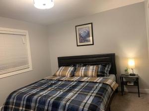 a bedroom with a bed with a plaid comforter at Exquisite 3 BR Villa with Double Garage-King Bed in Regina