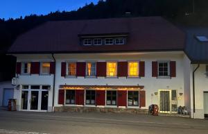 a large white building with red shuttered windows at Forest Apartment-Forest Escape Menzenschwand in St. Blasien