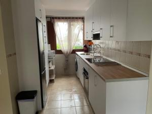 una pequeña cocina con armarios blancos y una ventana en El Puerto, en figueras