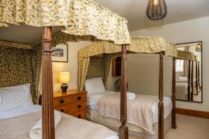 1 dormitorio con 2 camas con dosel y espejo en Watermouth Castle, Penn-Curzon Apartment, en Ilfracombe