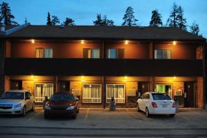three cars parked in a parking lot in front of a building at Cloud 9 Inn in Whitecourt