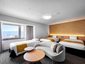 Habitación de hotel con 2 camas y sofá en Daiwa Roynet Hotel Wakayama en Wakayama
