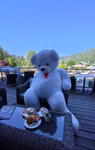 een grote witte teddybeer op een stoel bij Hôtel Le Labrador 1971 in Les Gets