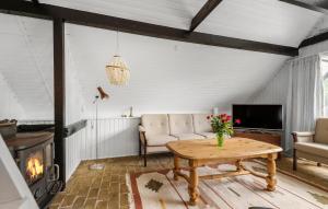 a living room with a table and a couch and a tv at 3 Bedroom Lovely Home In Hemmet in Hemmet