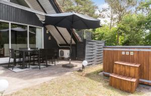 a patio with an umbrella and a table and chairs at 3 Bedroom Lovely Home In Hemmet in Hemmet +10 photos