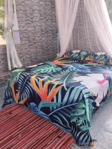 uma cama com um cobertor colorido em cima em Tapuhere Lodge em Fare