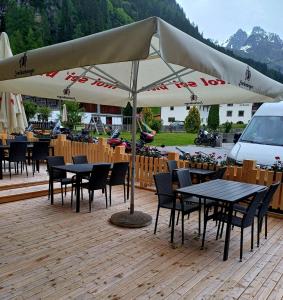 einen Tisch und Stühle unter einem Schirm auf einer Terrasse in der Unterkunft Hotel Restaurant Liesele Sonne in Sankt Leonhard im Pitztal