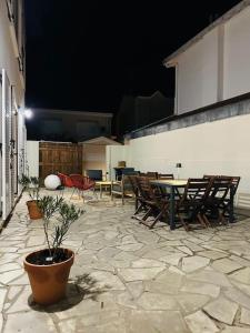 een patio met tafels en stoelen en een potplant bij Maison Ausiphica in Arcachon