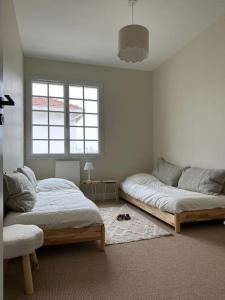 een slaapkamer met twee bedden en een raam bij Maison Ausiphica in Arcachon