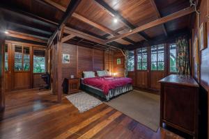 a bedroom with a bed in a room with wooden walls at The Fern Lodge in Bedugul