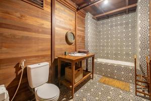 a bathroom with a toilet and a wooden wall at The Fern Lodge in Bedugul +31 photos