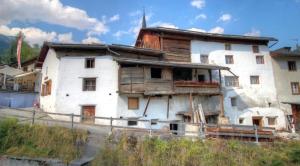 圣玛利亚瓦尔姆斯塔尔Chasa Jaro的一座带有阳台的旧白房子